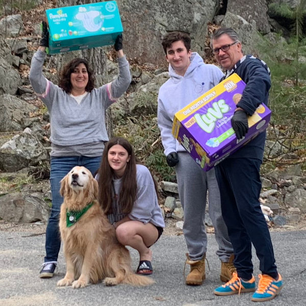 family holding up boxes of diapers