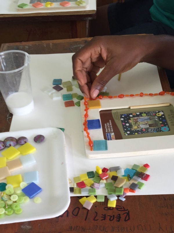 hand gluing down beads around a picture frame