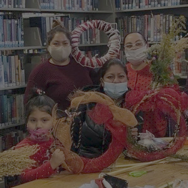 women and child holding up wreaths