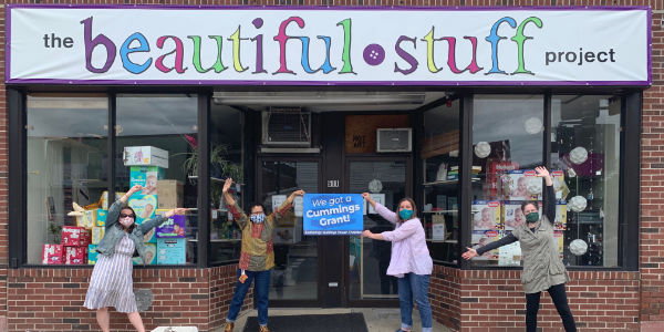 women holding up a sign that says we got a Cummings grant