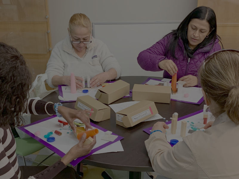 A group of women building towers with random objects