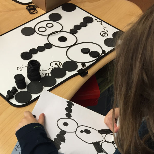 child drawing a design made from dots